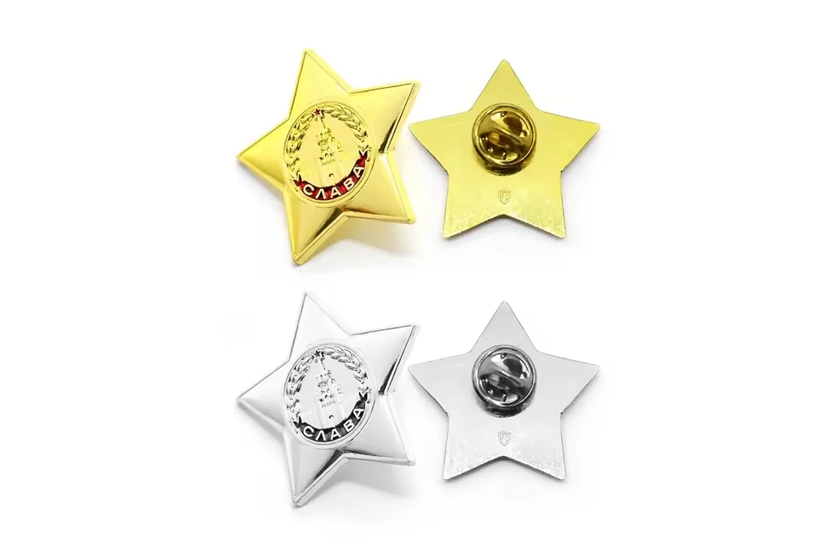 Gold and silver star pins shown with metal butterfly clutches on their reverses.